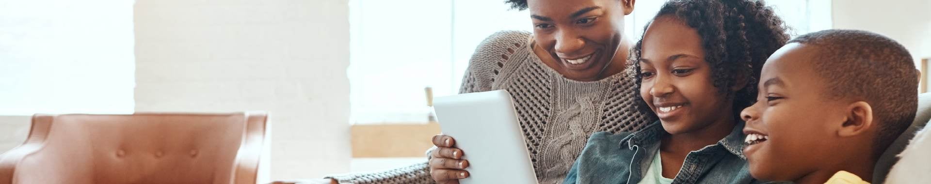 Family on couch looking at tablet